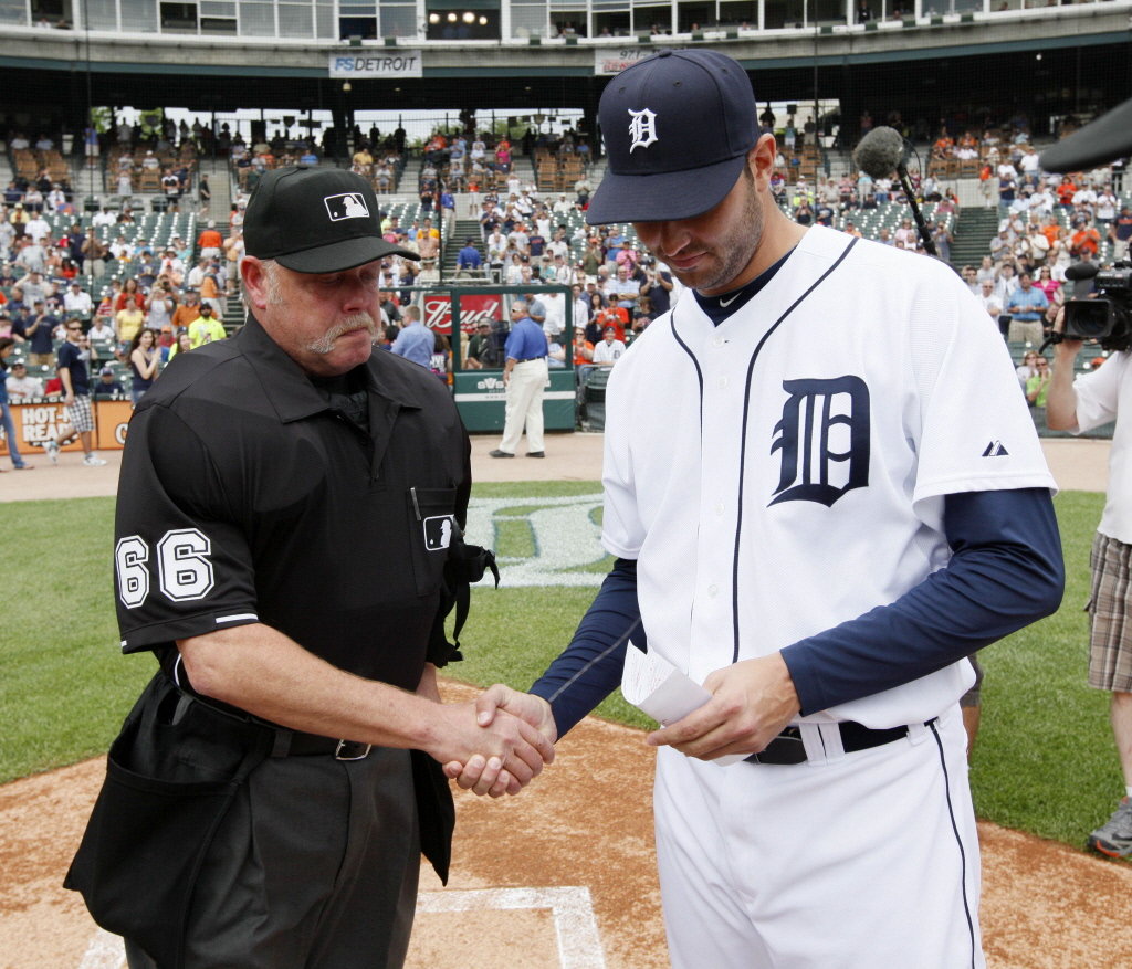 Detroit Tigers' Armando Galarraga, right, and umpire Jim Joyce shake hands the day after Joyce's blown call cost Galarraga a perfect game in 2010 (MLB.COM)