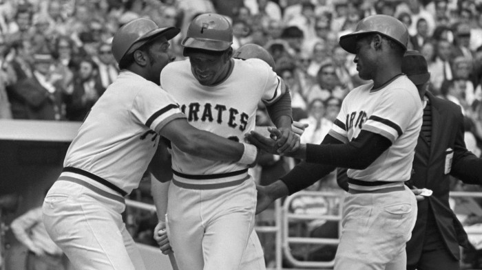 Willie Stargell, left, hugs his Pittsburgh Pirates teammate Al Oliver, center, as Roberto Clemente looks on during the 1971 season. On September 1, 1971, the Pirates fielded an all-Black lineup of African-American and Latino players, a first in the history of Major League Baseball. (MLB.com)